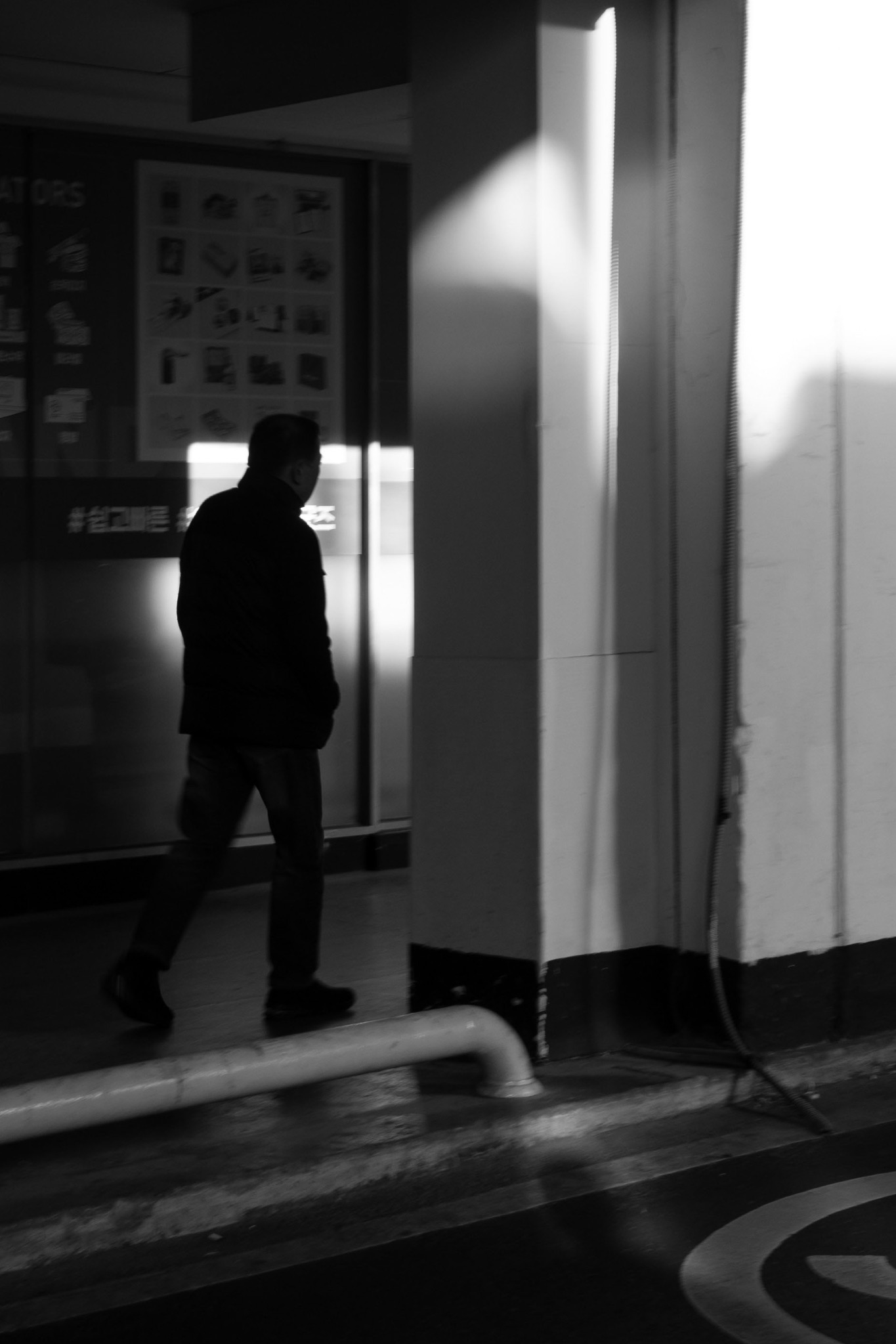 A lone figure passing through shadow